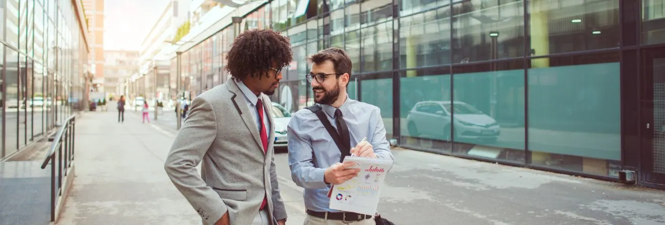 Two business people walking: Questions to Ask Your Real Estate Agent